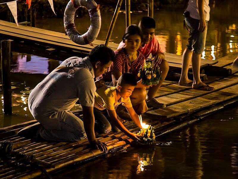 Thai_people_setting_their_candle-lit_krathongs_in_the_Ping_river_at_night_during_Loy_Krathong_2015-10_(22715933524)